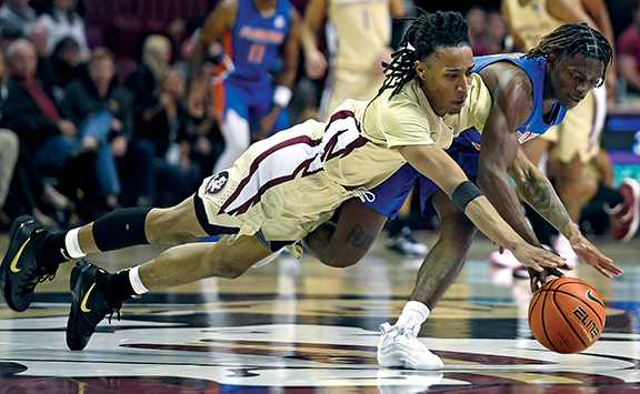 Florida State Seminoles guard Caleb Mills and Florida Gators forward Trey Bonham dive for a loose ball during the second half at Donald L. Tucker Center.